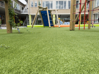 image of artificial grass installed on the floor of a children's playground and climbing frame