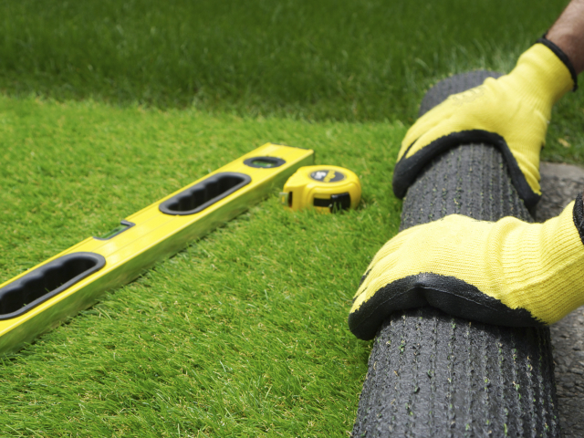 man measuring artificial grass