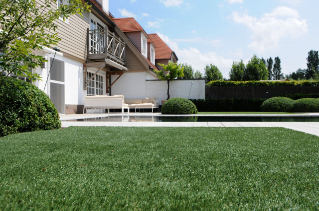 image or artificial grass installed in a modern country garden next to pool