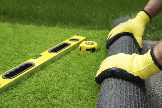 man measuring artificial grass